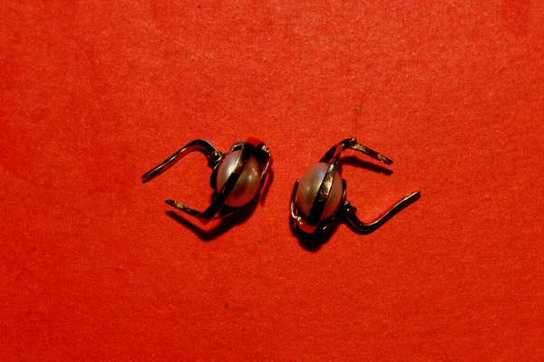Zwei Goldene Ohrringe Mit Perlen Liegen Auf Einem Roten Tuch — Stockfoto