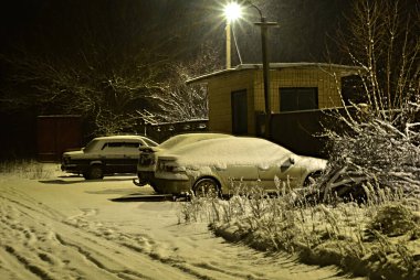 Tüylü kar, arazide duran arabaların çatılarını kapladı..