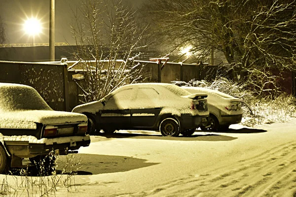 The falling snow covered the cars standing on the site. — Stock Photo, Image