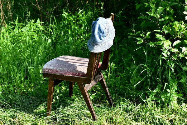 Ogrodzie Krzakach Stoi Zapomniane Drewniane Krzesło Wysokim Oparciem Którym Wisi — Zdjęcie stockowe