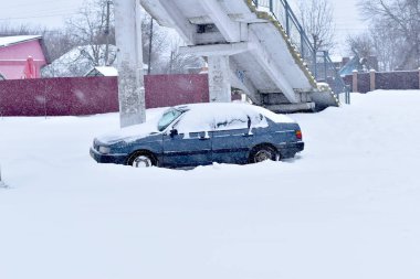 Karla kaplı otoparka bir araba park etmiş..