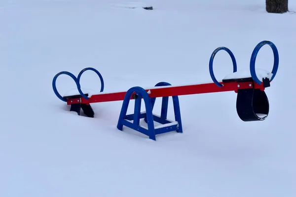 The heavy snow that fell fell asleep on the children's swing. High quality photo