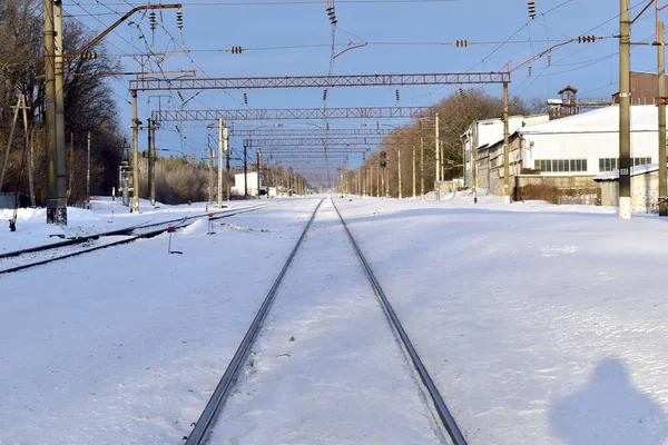 SnThick snow completely covered the railway tracks that stretch to the horizon.ow-covered railway tracks. High quality photo