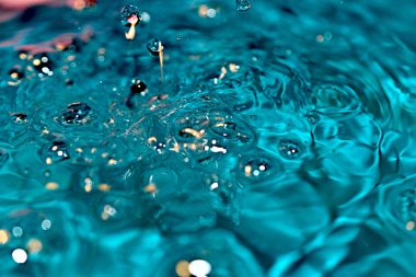 Suyun kaynayan yüzeyinin ve serbest düşen damlaların bir görüntüsü..