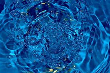 Su yüzeyine düşen damlacıklar çok sayıda dalga oluşturdu..