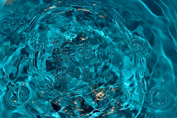 Üzerinde hava kabarcıkları olan kaynayan mavi bir su yüzeyinin görüntüsü..