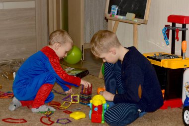 İki kardeş evde inşaatçıyla birlikte oynuyorlar..