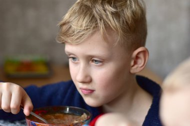 Çocuk yemek yerken televizyonda ilginç bir program izliyor..