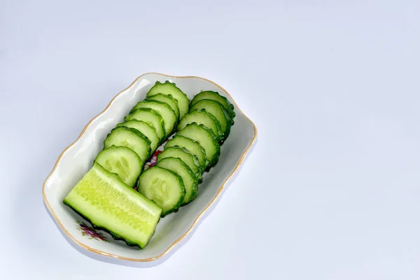 A close-up of two rows of sliced green cucumber on a plate. — Stock Photo, Image