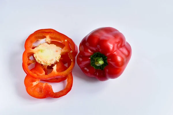 Poivron rouge tranché en rondelles sur blanc. — Photo