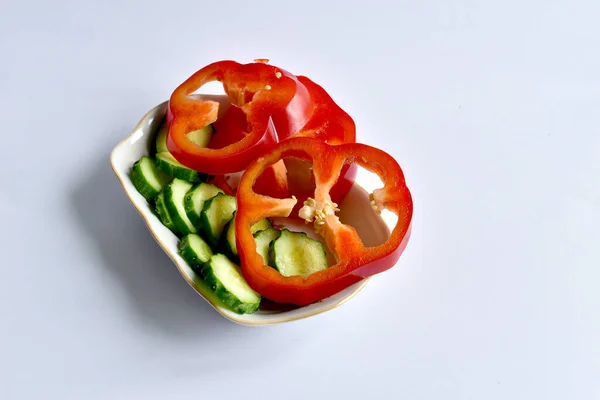 Tabakta kırmızı biber ve dilimlenmiş salatalık..