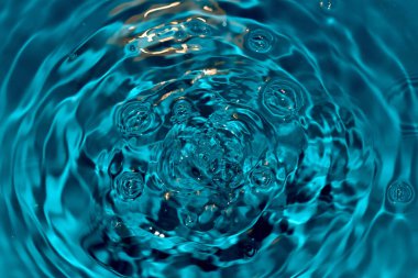 Damlalardan gelen dalgalarla su yüzeyi.