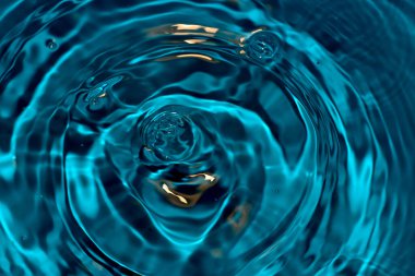 Düşen damlalardan suyun üzerinde daireler ve kabarcıklar.