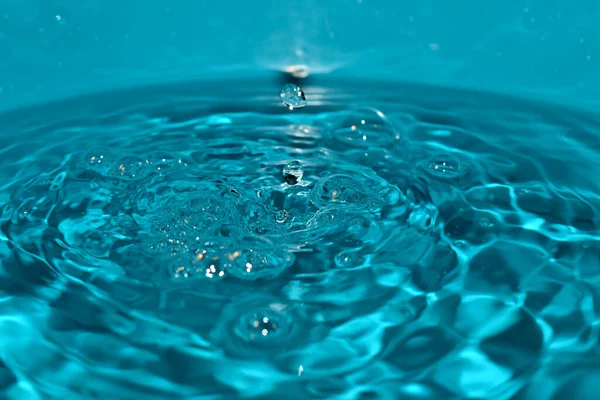 Gotas de agua caen continuamente sobre la superficie del líquido. — Foto de Stock