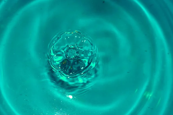 Salpicadura de ondas circulares de una gota de agua que cae. — Foto de Stock