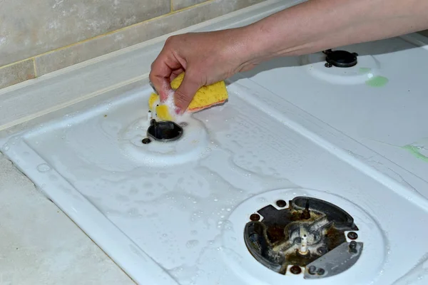 Woman wipe the surface of the gas stove with a sponge near the burner. — Stock Photo, Image