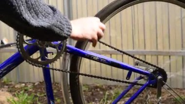 Bisiklet pedalını çeviren adam dişli, zincirli ve arka tekerleği döndürür..