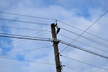 Üzerinde elektrik kabloları olan somut bir destek..