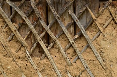 Ahırın eski duvarı kiremitlerle kaplanmış ve çamurla kaplanmış..