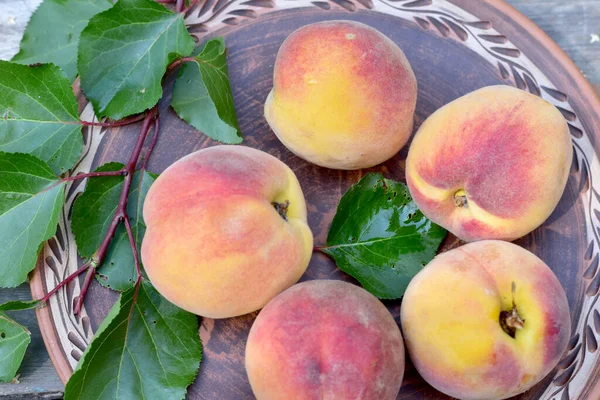 Close-up shot of ripe peaches on a plate, taken from above. — Stock Photo, Image