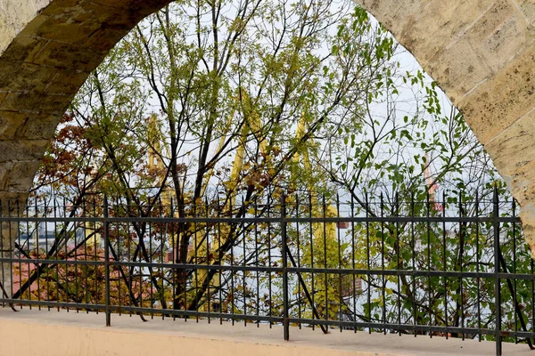 Arco de pedra com barras de ferro perto do porto. — Fotografia de Stock