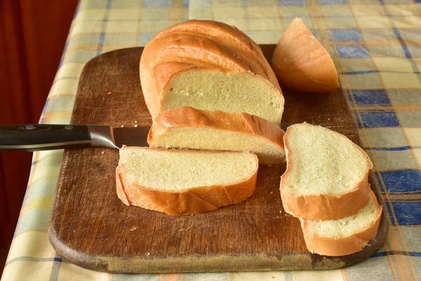 在切菜板上有一块被切碎的面包和一把宽刀 — 图库照片