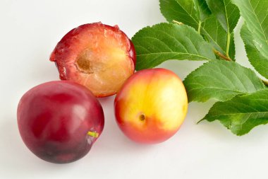 İki büyük kiraz eriği ve bir yarısı masanın üzerinde..