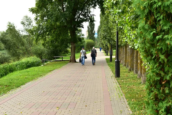 Мужчина и женщина идут по тропинке городского парка. — стоковое фото