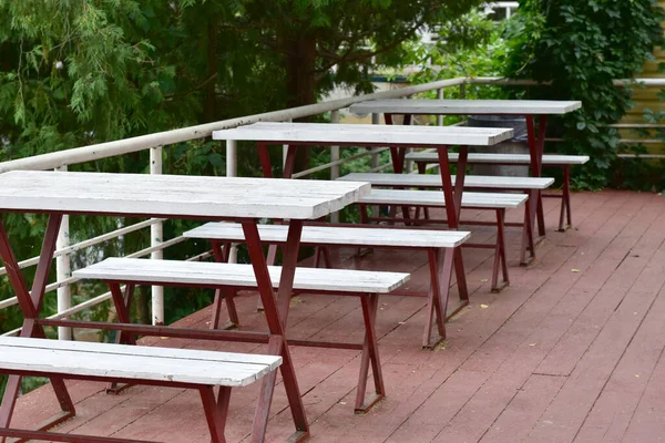 Tische und Bänke eines Straßencafés ohne Besucher. — Stockfoto