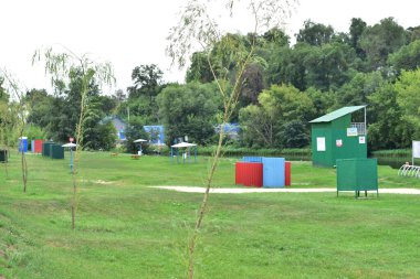 Nehir kıyısında banyo kulübeleri ve banklar..