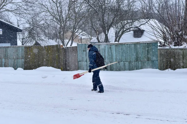 Inverno. Un uomo cammina lungo una strada rurale. — Foto Stock