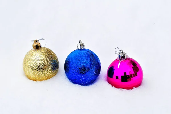 Christmas. Three balls lie in the snow, a decoration for the Christmas tree. — Stock Photo, Image