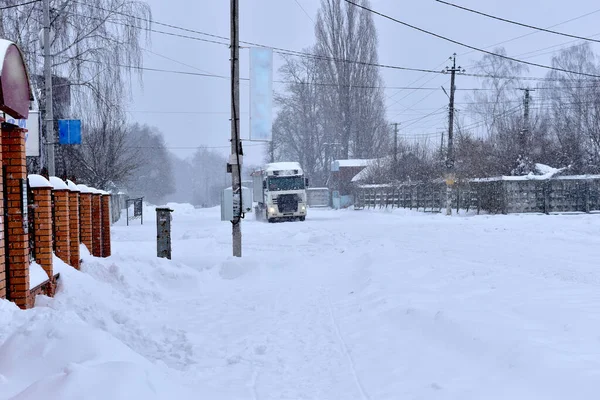 Грузовик едет по дороге, покрытой снегом. — стоковое фото