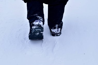 Kış. Kış yolunda yürüyen bir yayanın bacakları..