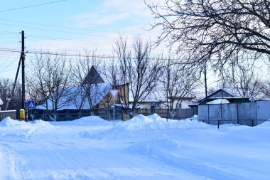 Kış. Köyün varoşlarında. Evler ve yollar karla kaplıydı..