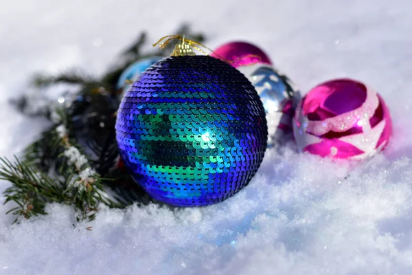 Decoraciones navideñas y una gran bola yacen en la nieve. — Foto de Stock