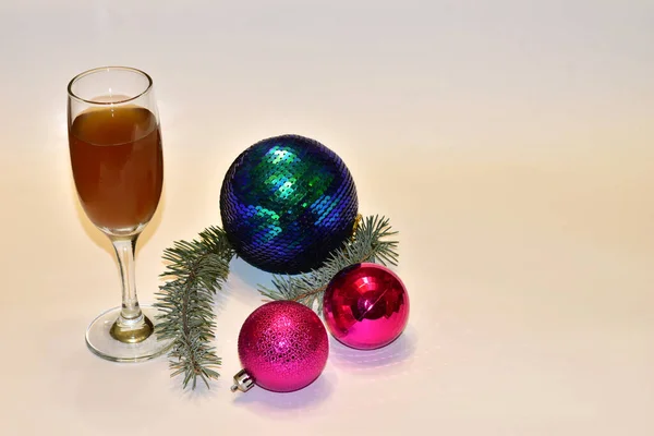 A glass of wine and glass balls on the table. — Stock Photo, Image