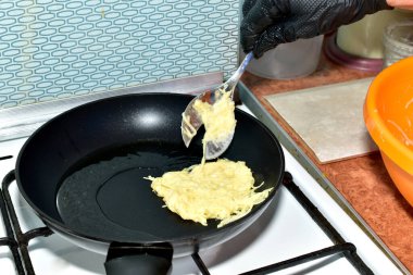 Patates gözlemeleri gaz sobasında kızartma tavasında kızartılır..