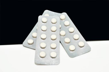 Siyah ve beyaz arka planda birkaç paket hap var..