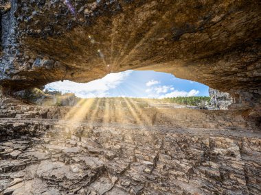Güneş ışığı bir kaya deliğinden içeri giriyor.