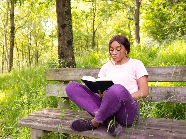 Młoda Czarna Kobieta Siedzi Ławce Parku Czyta Książkę — Zdjęcie stockowe