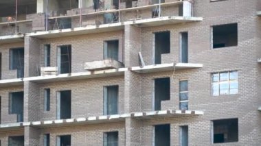 İnşaat işçileri bir gökdelen inşa etmek için yeni bir bina inşa ettiler. Binaların ve binaların inşaatında inşaatçı ya da tamirci olarak çalıştılar. Yüksek bir binanın dikey panoraması..