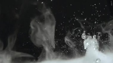Sulu su damlaları ve sisli videoları rahatlatıyor ya da siyah bir arkaplanda döngü yapabilen dumanlar. Su yakın planda sıçrar. Su damlar ve hareket halinde zıplar. Kimyasal reaksiyon suyu.