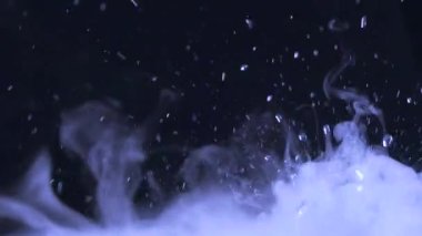 Sulu su damlaları ve sisli videoları rahatlatıyor ya da siyah bir arkaplanda döngü yapabilen dumanlar. Su yakın planda sıçrar. Su damlar ve hareket halinde zıplar. Kimyasal reaksiyon suyu.