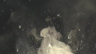 Sulu su damlaları ve sisli videoları rahatlatıyor ya da siyah bir arkaplanda döngü yapabilen dumanlar. Su yakın planda sıçrar. Su damlar ve hareket halinde zıplar. Kimyasal reaksiyon suyu.