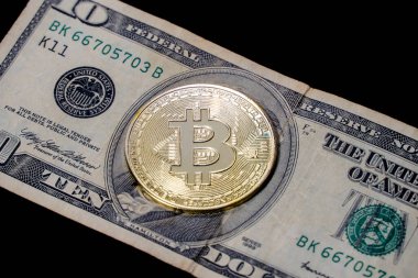 Bitcoin parası yakın planda 10 dolarlık banknotun üzerinde duruyor. Para ve Finans.