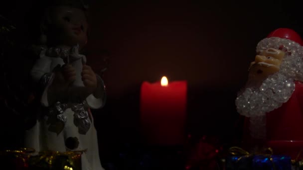 圣诞节或新年前夕 天使和圣诞老人晚上带着礼物在点燃的蜡烛的背景下 新年假期 — 图库视频影像