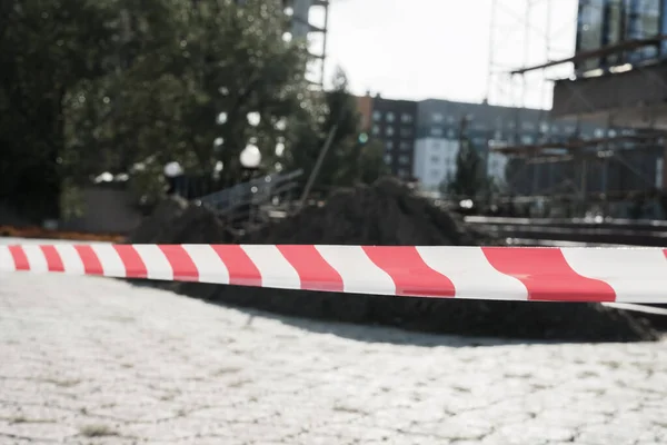 Red and white lines of barrier tape warning of danger during the construction and repair of buildings. Red and white warning Tape pole guard protects against penetration