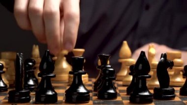 Satranç masası oyunu. Oyuncu satrançta taşları keser. Spor Stratejisi ve kumar. Oyuncu, masada siyah bir anahtarla oturan bir adam. Kumar masasında gömlekli bir adam..