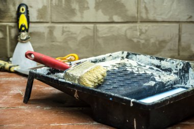 İnşaat ve boyama aletleri evin onarımı ve restorasyonu sırasında yerde yatar. Evde tamirci ya da tamirci olarak çalış. Bir odayı bitirmek ya da onarmak.